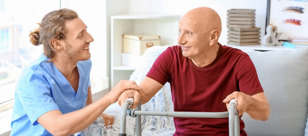 קשיש עם הליכון יושב עם מטפל