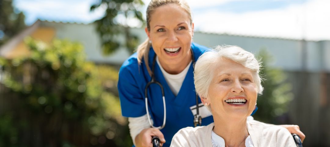 קשישה בכיסא גלגלים עם מטפלת