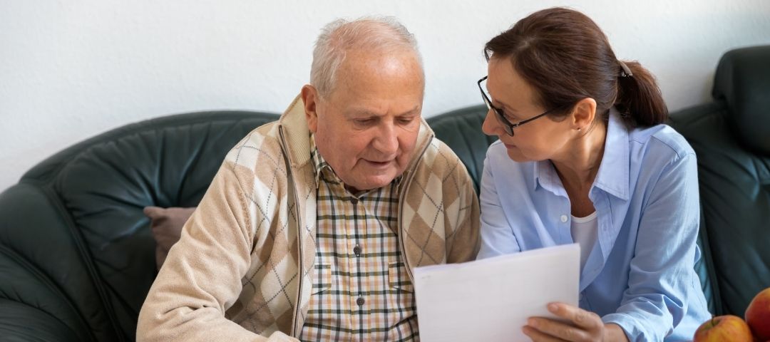 קשיש ועובדת סוציאלית עוברים על טפסים