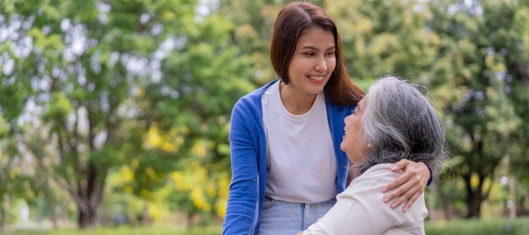 אישה מבוגרת יושבת ומטפלת נותנת לה חיבוק