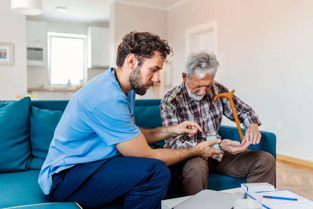 מטפל וקשיש יושבים על ספה כחולה
