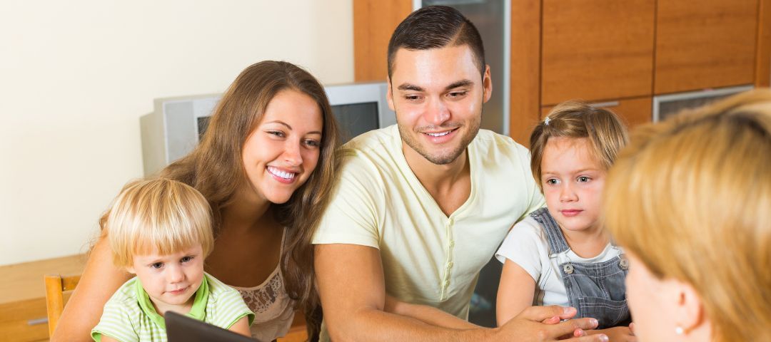 הורים ו-2 ילדים יושבים אל מול עו"ס