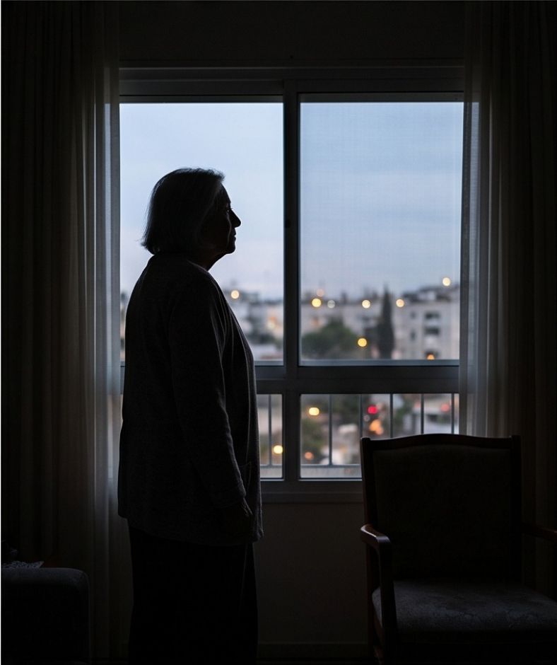 קשישה מביטה אל החלון